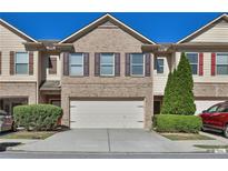 Charming brick townhome featuring a two-car garage and manicured landscaping in a well-maintained community at 328 Oaktown Ct, Lawrenceville, GA 30044