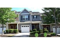 Charming townhome with gray siding, white garage door and driveway with manicured landscaping at 532 Oakside Pl, Acworth, GA 30102