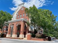 Beautiful brick condominium building featuring an arched entryway and mature trees at 1850 Cotillion Drive Dr # 2416, Atlanta, GA 30338