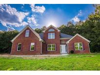 Charming red brick home with a lush green lawn and mature trees at 4085 Fawn Valley Dr, Loganville, GA 30052