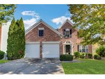 Charming two-story brick home featuring a well-manicured lawn, two-car garage, and a welcoming entrance, perfect for suburban living at 3704 Ramsey Sw Cir, Atlanta, GA 30331