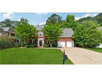 Charming brick home with a two-car garage, well-manicured lawn, and mature trees at 5013 Kendall Nw Sta, Acworth, GA 30102