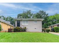 Charming single-story home with a well-manicured lawn and lush landscaping at 933 Capitol View Nw Ave, Atlanta, GA 30318