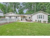 Charming single-story home with a well-manicured lawn, inviting patio, and beautiful landscaping at 1652 Tryon Ne Rd, Atlanta, GA 30319