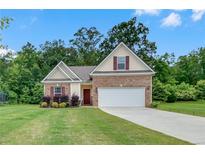 Charming single-Gathering home with manicured lawn, brick accents, and a two-car garage at 1431 Beckett Dr, Hampton, GA 30228