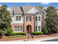 Charming brick home with manicured landscaping, symmetrical design, and a welcoming arched entryway at 255 Kendemere Pointe, Roswell, GA 30075