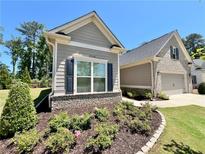 Charming home exterior featuring a well-manicured lawn and beautiful landscaping with flower beds at 3165 Blackshear Dr, Marietta, GA 30060