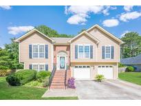Charming two-story home featuring a brick-accented entrance, tidy lawn, and a two-car garage at 435 Flowering Trl, Grayson, GA 30017