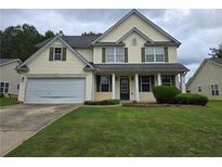 Charming two-story home with green lawn and attached two car garage at 5578 Swanson Rd, Ellenwood, GA 30294