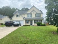 Charming two-story home with a well-maintained lawn, attached garage, and classic curb appeal at 5578 Swanson Rd, Ellenwood, GA 30294