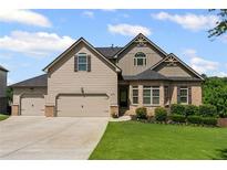 Charming two-story home with three-car garage, manicured lawn, and brick accents at 6310 Stillwood Ln, Cumming, GA 30041