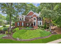 Charming two-story brick home with manicured front yard, lush landscaping, and inviting curb appeal at 750 Highview Ct, Woodstock, GA 30189