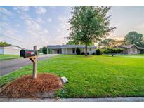 Charming single-story home featuring a lush green lawn, mature shade tree, and well-maintained landscaping at 2091 Moon Drive Sw, Conyers, GA 30094