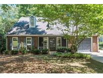Charming brick home with a well-manicured lawn and attached garage at 402 Roswell Green Ln, Roswell, GA 30075