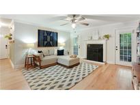 Cozy living room with hardwood floors, modern ceiling fan, and a fireplace at 1412 Oakridge Cir, Decatur, GA 30033