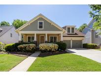 Charming home with inviting front porch, lush landscaping, and attached two-car garage at 6418 Crown Forest Ct, Mableton, GA 30126