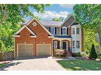Beautiful two-story home with manicured lawn, brick facade, and two-car garage offers great curb appeal at 5060 Winship Ct, Alpharetta, GA 30009