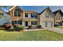 Charming two-story home featuring a well-maintained lawn, manicured shrubs, and a welcoming front entrance at 514 Jadetree Ln, Atlanta, GA 30349