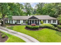 Charming ranch-style home with a beautifully landscaped front yard and circular driveway at 5860 Riverwood Dr, Sandy Springs, GA 30328