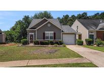 Charming one-story home with stone accents, well-maintained lawn, and attached garage at 855 Lakeside Cir, Covington, GA 30016