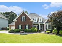 Beautiful red brick home with a well-manicured lawn and mature landscaping at 402 Lake Point Trce, Canton, GA 30114