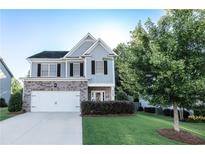 Charming two-story home with a well-manicured lawn, brick accents, and a two-car garage at 4305 Huron Dr, Cumming, GA 30028