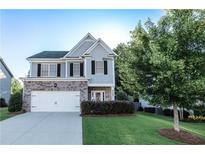 Charming two-story home with brick and gray siding, an attached garage, and a well-maintained lawn at 4305 Huron Dr, Cumming, GA 30028