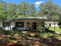 Charming single story home with covered porch, shutters, and mature trees at 1272 Cave Springs Rd, Douglasville, GA 30134