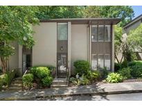 Two-story townhouse with neutral exterior, surrounded by mature trees and landscaping at 46 Ivy Ne Rdg, Atlanta, GA 30342