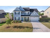 Charming two-story home featuring a well-manicured lawn and a two-car garage at 55 Clubhouse Way, Acworth, GA 30101