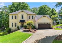 Charming two-story traditional home with manicured lawn and attached two-car garage at 3977 Fox Glen Dr, Woodstock, GA 30189