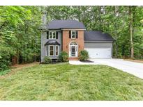Charming home featuring a brick front, gray siding, well-manicured lawn, and an attached two-car garage at 4806 Deer Chase, Powder Springs, GA 30127