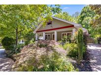 Charming home exterior featuring a covered front porch, lush landscaping, and mature trees at 1405 May Se Ave, Atlanta, GA 30316