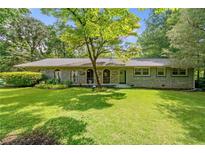 Charming brick home with a well-manicured lawn and mature tree offering plenty of shade at 265 Tamea Trl, Covington, GA 30014