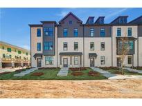 Attractive townhome showcases classic brickwork, multiple windows, and professionally manicured landscaping at 445 Breccia Run, Mcdonough, GA 30253
