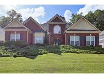 Charming two-story brick home featuring a manicured lawn and mature landscaping at 6772 Blantyre Boulevard Blvd, Stone Mountain, GA 30087