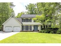 Charming two-story home featuring a well-manicured lawn, blue door, and a two-car garage at 3707 Dunwoody Club Dr, Atlanta, GA 30350