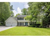 Charming two-story home featuring a well-manicured lawn, symmetrical design, and a welcoming blue front door at 3707 Dunwoody Club Dr, Atlanta, GA 30350