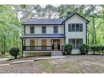Charming two-story home with a welcoming front porch nestled amongst mature trees at 315 N Fayette Dr, Fayetteville, GA 30214