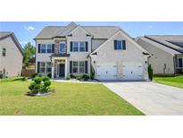 Beautiful two-story home with a manicured lawn, a two-car garage, and a classic brick facade at 383 Crestbrook Ln, Dallas, GA 30157