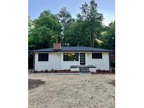 Charming single-story home with a brick chimney, fresh exterior paint, and a well-manicured front yard at 450 Collier Ridge Nw Dr, Atlanta, GA 30318