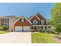 Charming two-story brick home with a well-manicured lawn and two-car garage at 4610 Admiral Ridge Way, Lilburn, GA 30047