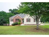 Charming one-story home featuring a brick accent, well-maintained lawn, and mature trees enhancing curb appeal at 409 Cold Springs Ln, Mcdonough, GA 30252