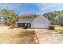 Charming single-story home with a two-car garage, stone accents, and inviting front porch on a spacious lot at 704 Stonecrest Ln, Loganville, GA 30052