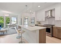 Modern kitchen featuring an island with bar seating that flows into a living room with large windows and great views at 775 Juniper St # 405, Atlanta, GA 30308