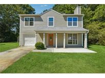 Charming two-story home with a well-manicured lawn, covered porch, and attached garage at 6223 Marbut Farms Ln, Lithonia, GA 30058