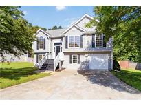 Charming two-story home featuring a well-maintained lawn, garage, and classic architectural details at 7186 Raintree Loop, Jonesboro, GA 30236