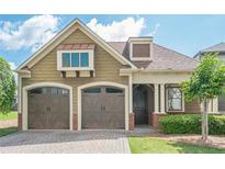 Charming home featuring a brick driveway, two-car garage, and manicured landscaping at 308 Rusty Gate Pass, Woodstock, GA 30189