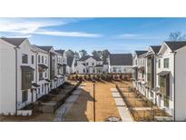 New construction townhomes feature modern architecture with white exteriors, dark accents, and landscaped common areas at 506 Healy Dr # 74, Cumming, GA 30040
