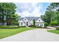 Stately white home with meticulously landscaped lawn and circular driveway at 965 Tiverton Ln, Alpharetta, GA 30022